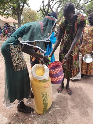 Frauen in Afrika erhalten Lebensmittel wie Maismehl gegen den Hunger