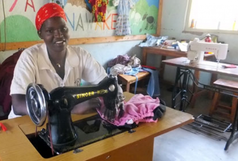 Eine Frau sitzt an einer Nähmaschine in Afrika