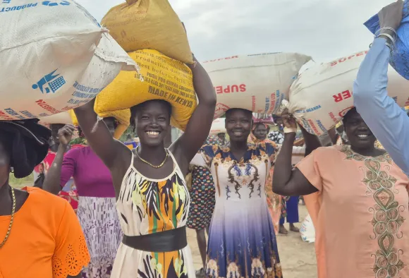Frauen holen Säcke mit Lebensmitteln ab