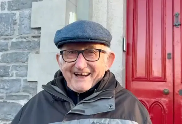 Pater Noel steht vor einer roten Tür.