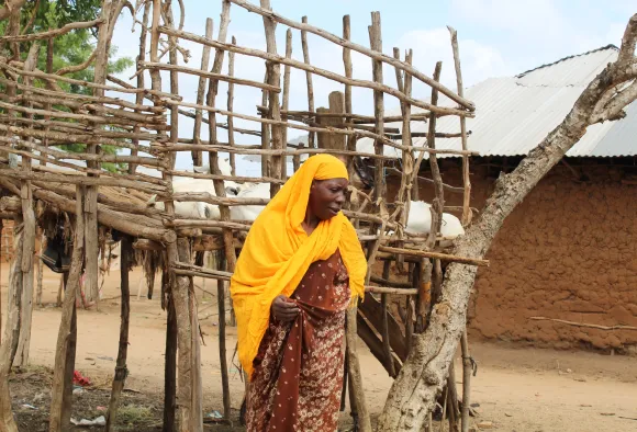Eine Frau in Afrika wartet auf Lebensmittel.